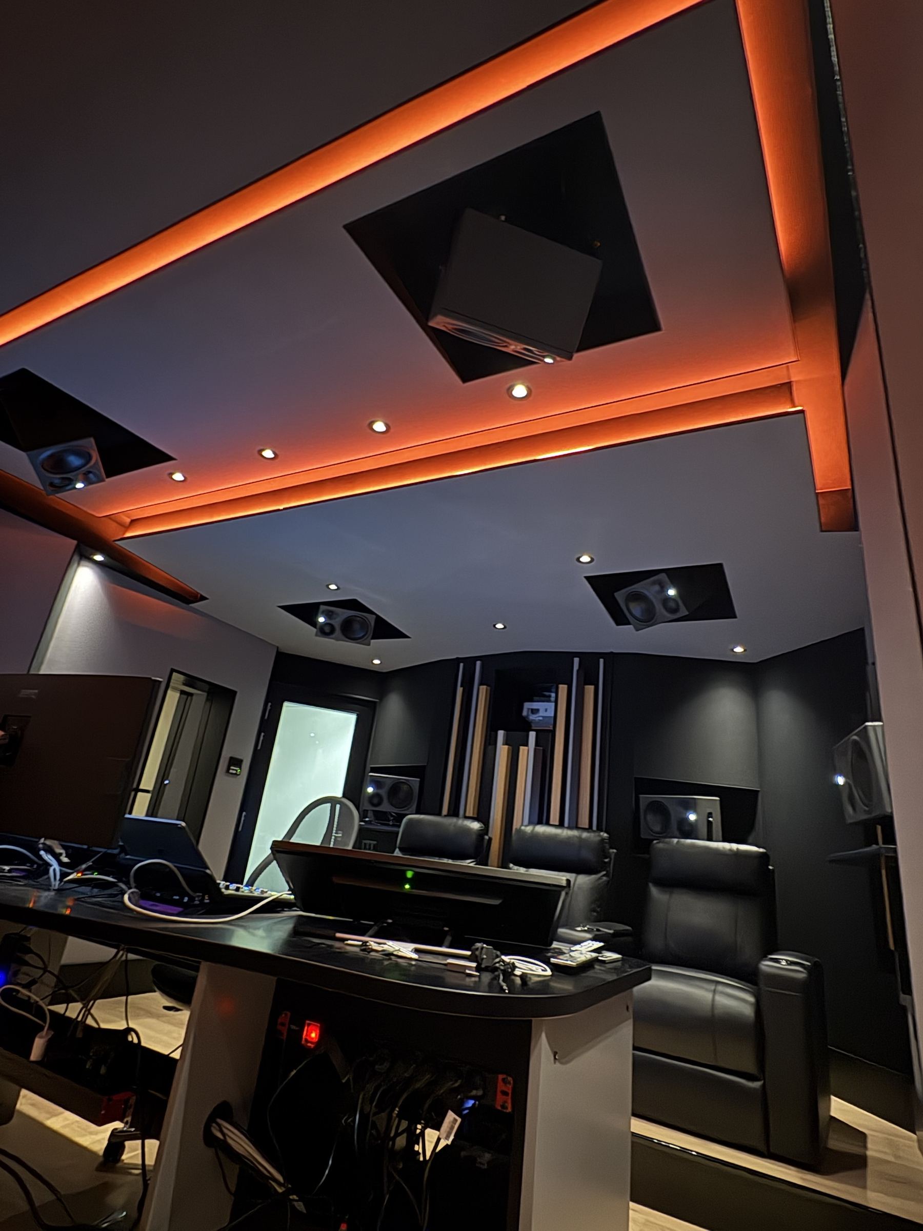 Regia con illuminazione LED calda, poltrone e finestra verso la sala di ripresa